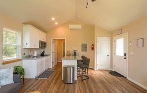 A spacious kitchen with white cabinets, a microwave, and a small island with bar stools. - Ponderosa Nest-BlueJay Nest 1hr drive to Yosemite (Mariposa County)