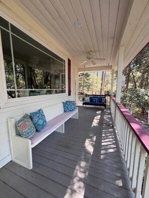 A covered porch with a bench and a railing. - Yosemite Firehouse Inn-Cottage (Mariposa County)