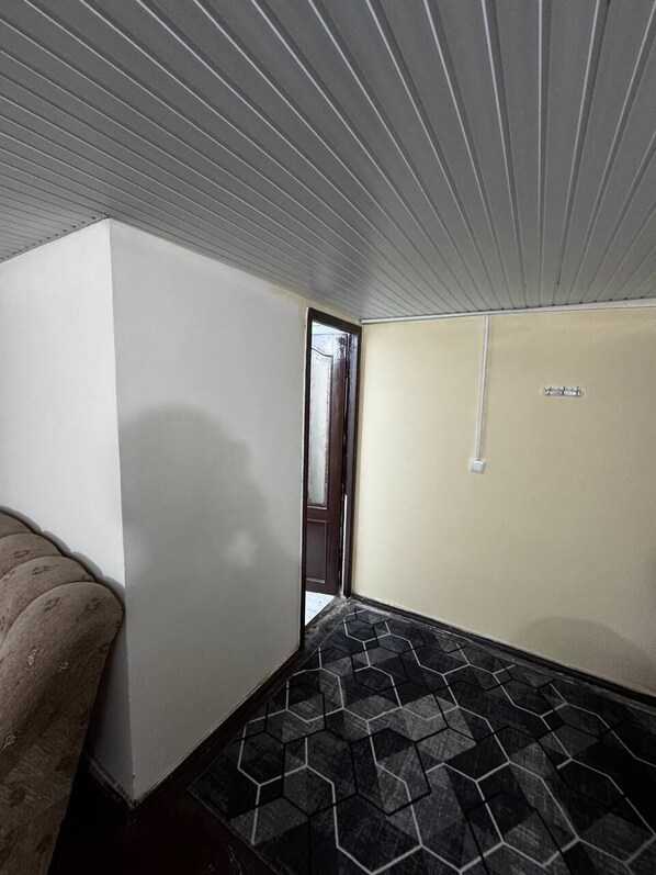 Una habitación con pared blanca, puerta y piso estampado.