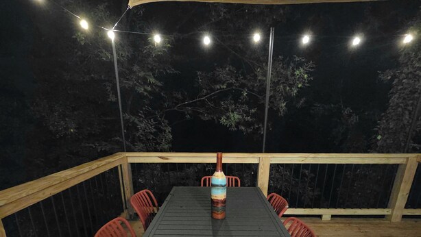 An outdoor deck with a table and chairs, surrounded by a wooden railing. - 5 Min to Downtown • Hot Tub • Game Room (Atlanta)