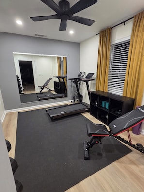 A home gym with a treadmill, stationary bike, and weight bench. - 5 Min to Downtown • Hot Tub • Game Room (Atlanta)