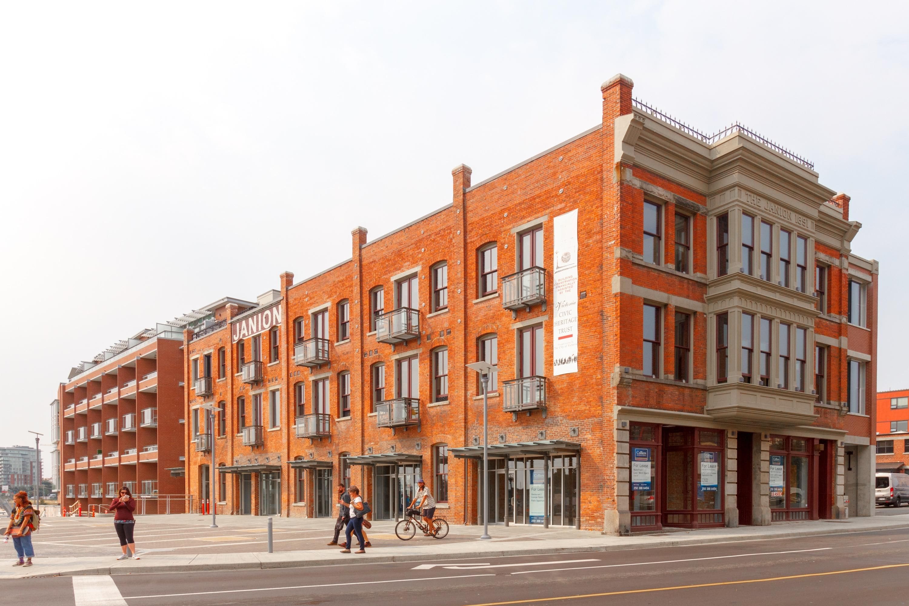 A multi-story brick building with a classic architectural style, featuring large windows and a balcony on the second floor.