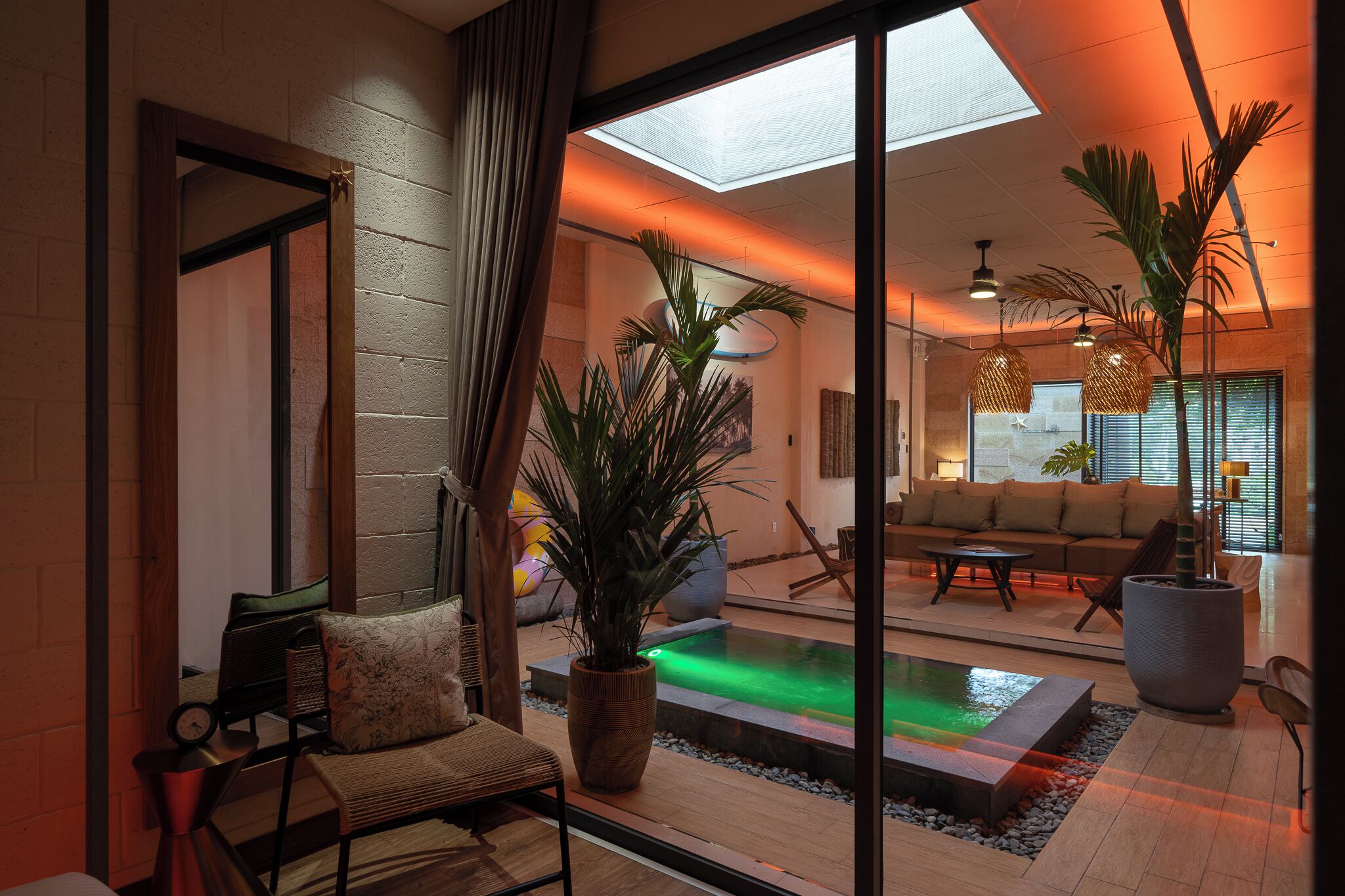 A modern interior with a pool, seating area, and large windows.