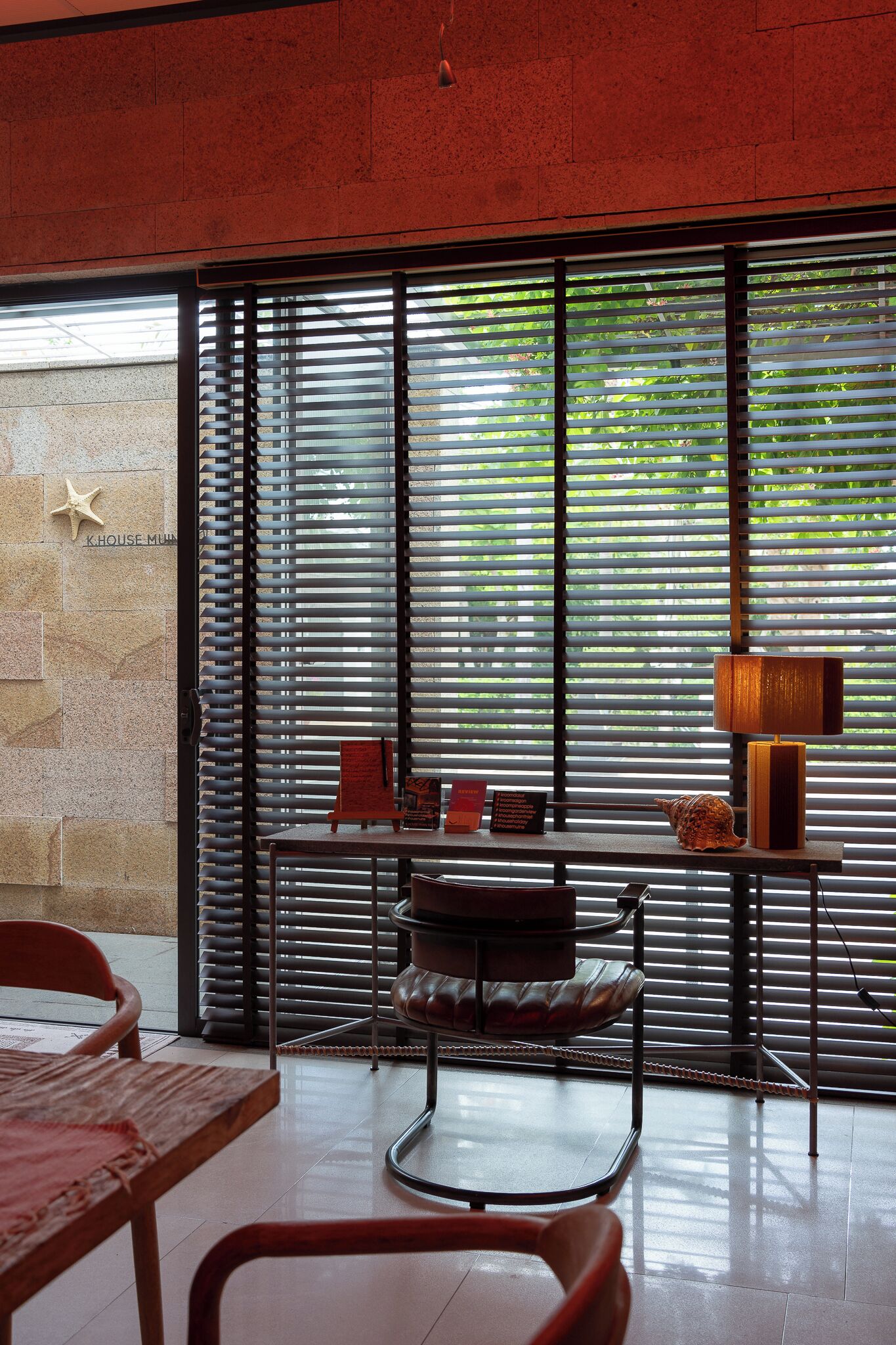 A modern interior with a large window, a starfish decoration, a table, and a chair.