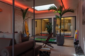 A modern hotel lobby with a pool, seating area, and large windows. - Mui Ne Beachside Private Villa (Mũi Né)