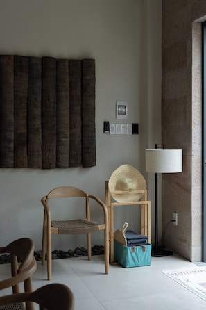 A room with a wooden chair, a woven basket, and a blue bag on the floor. - Mui Ne Beachside Private Villa (Mũi Né)