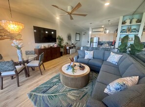 Ein modernes Wohnzimmer mit Sofa, Couchtisch und Essbereich.