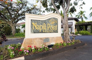 A sign for Napili Point Resort with a stone base and a plaque. - Oceanfront, swim with turtles, enjoy sunset views, all from your backyard. #B18 (Lahaina)