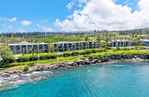 A coastal hotel with multiple-story buildings, a rocky shoreline, and clear blue water. - Oceanfront, swim with turtles, enjoy sunset views, all from your backyard. #B18 (Lahaina)