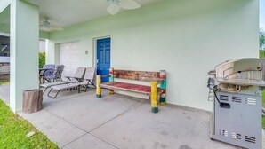 A covered outdoor area with a bench, chairs, and a barbecue grill. - Homosassa Riverfront Stay with Private Dock (Homosassa)
