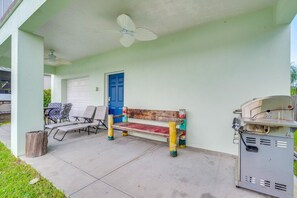 A covered outdoor area with a bench, chairs, and a barbecue grill. - Homosassa Riverfront Stay with Private Dock (Homosassa)