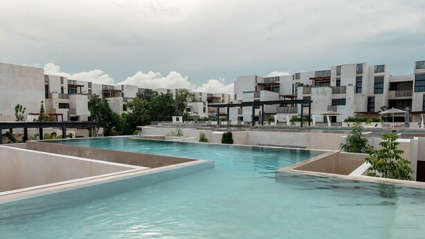 Area piscina sul tetto con edifici moderni sullo sfondo.