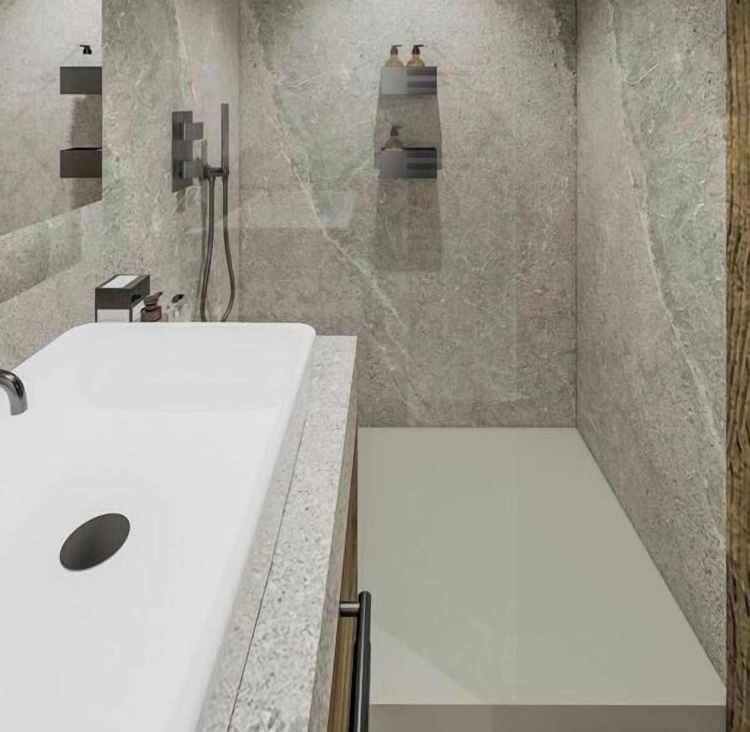 Une salle de bain avec un grand lavabo blanc, un espace douche et un miroir.