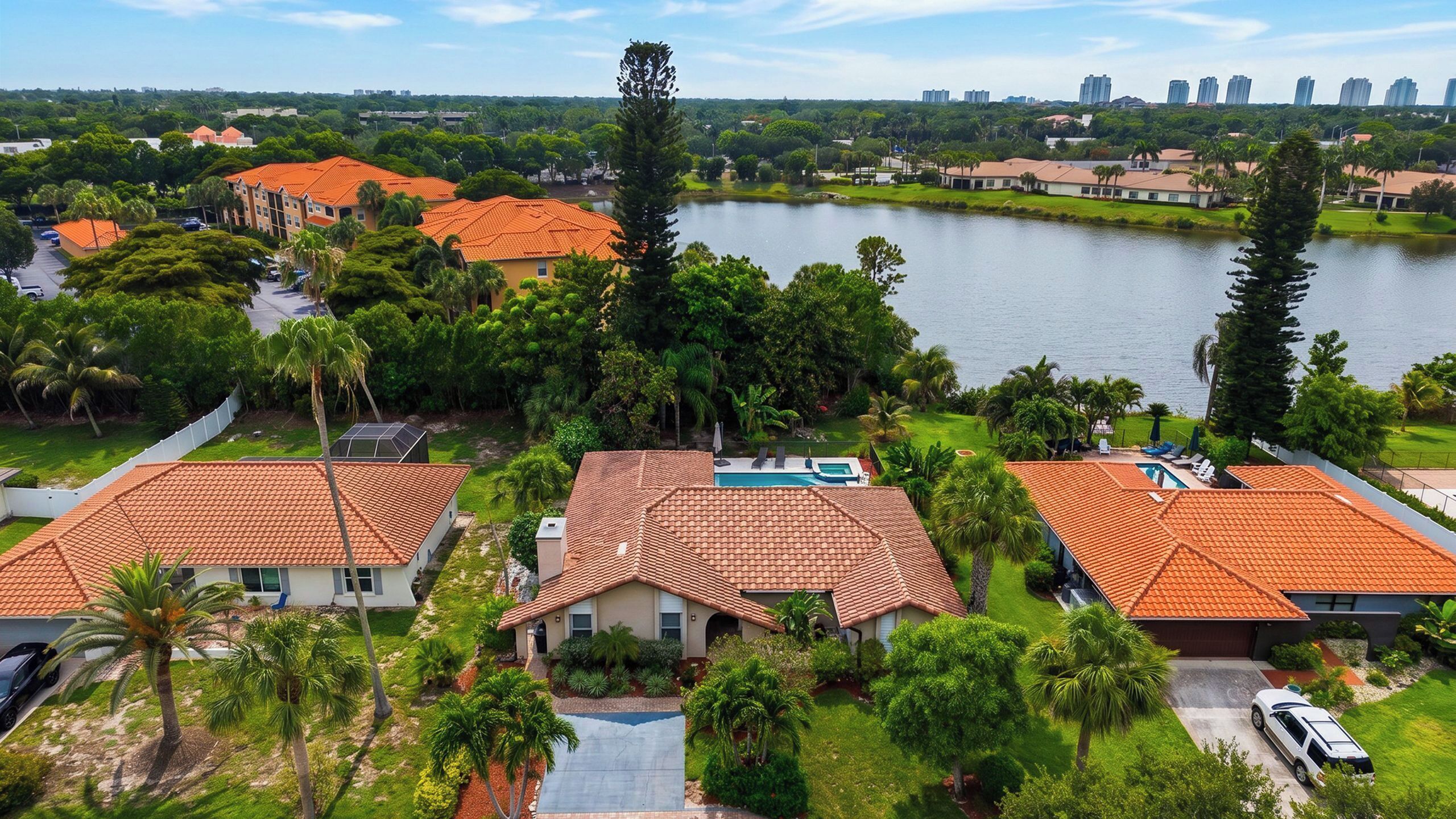 A residential area with houses, a swimming pool, and a lake.