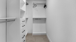 A walk-in closet with open shelves, a hanging rod, and a set of drawers. - El Mirador (Homestead)