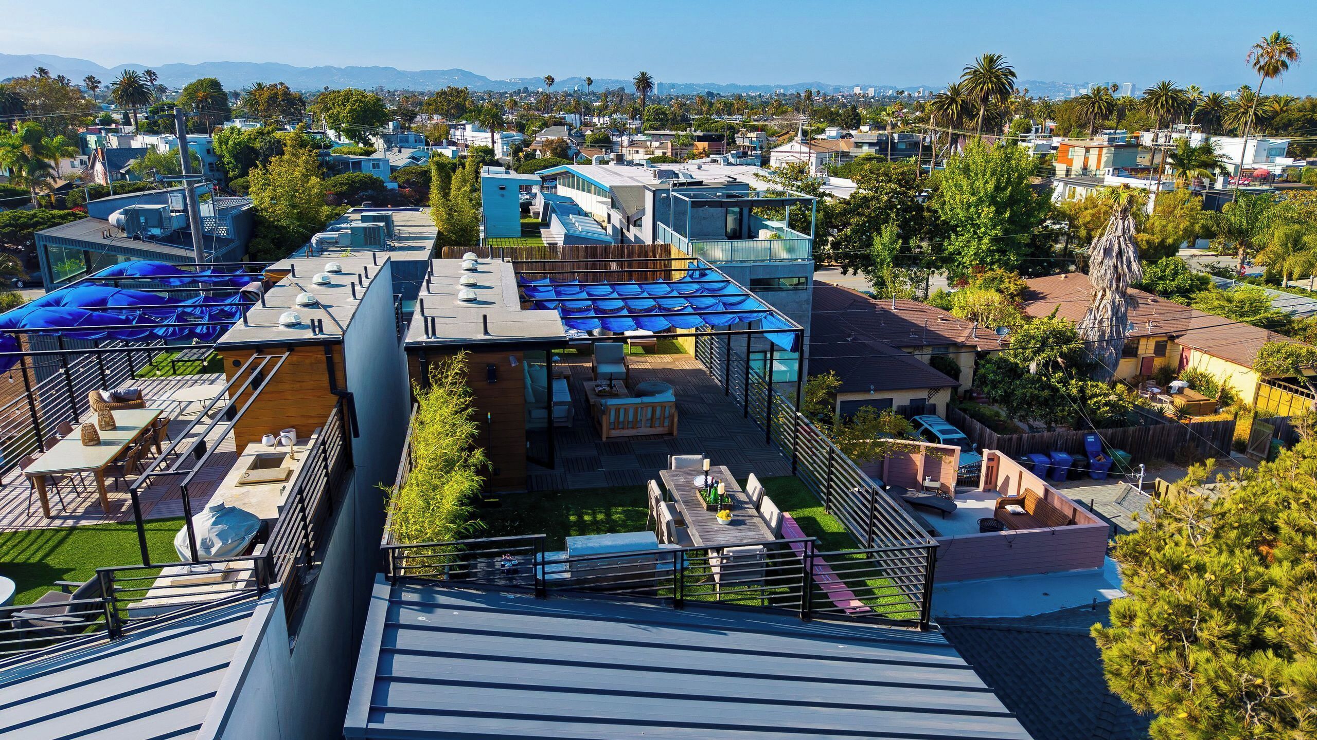 A residential area with modern houses, a rooftop patio with outdoor furniture, and a clear view of the surrounding neighborhood.