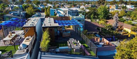 A residential area with modern houses, a rooftop patio with outdoor furniture, and a clear view of the surrounding neighborhood.