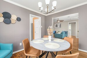 A dining area with a round table, chairs, a vase with flowers, and a ceiling fan. - Near UH, Rice University, Texas Medical Center & Downtown w/ Game Room (Houston)