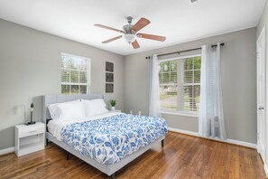 A bedroom with a bed, a nightstand, a ceiling fan, and a window with blinds. - Near UH, Rice University, Texas Medical Center & Downtown w/ Game Room (Houston)