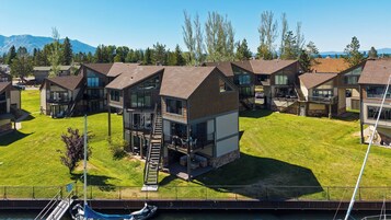 Un complejo residencial con varias casas de dos pisos, una estructura central elevada con balcón y un jardín.