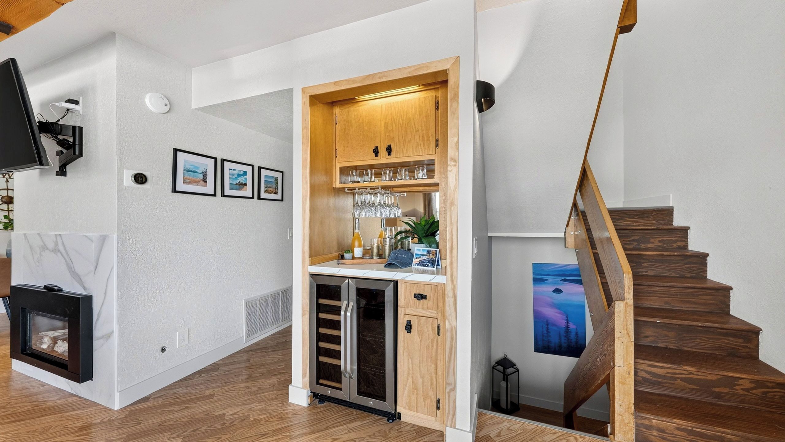 Een moderne keuken met een inbouw wijnrek, een open haard en een trap.