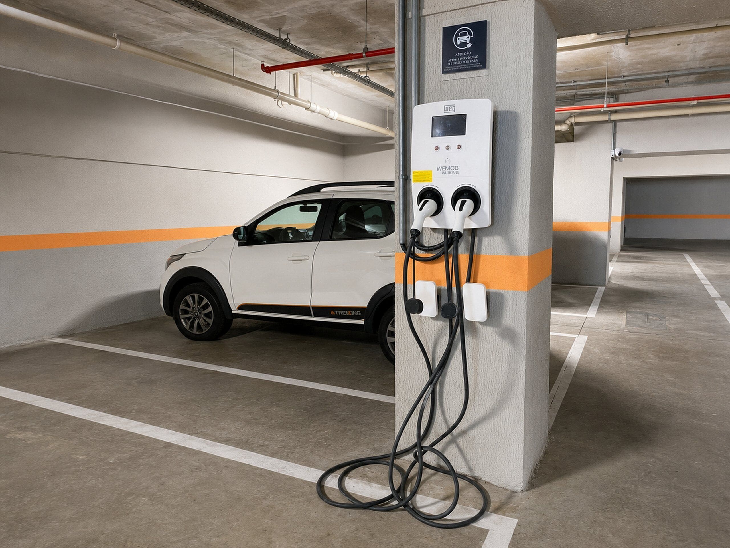 A parking garage with a white car parked near a charging station.