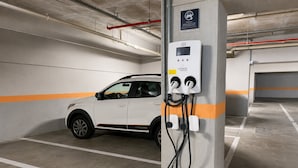 A parking garage with a white car parked near a charging station. - Hosts BR - Studio GAV Resorts (Ipojuca)