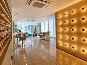 A modern interior with a polished floor, seating areas, and a wall with circular light fixtures. - Hosts BR - Studio GAV Resorts (Ipojuca)