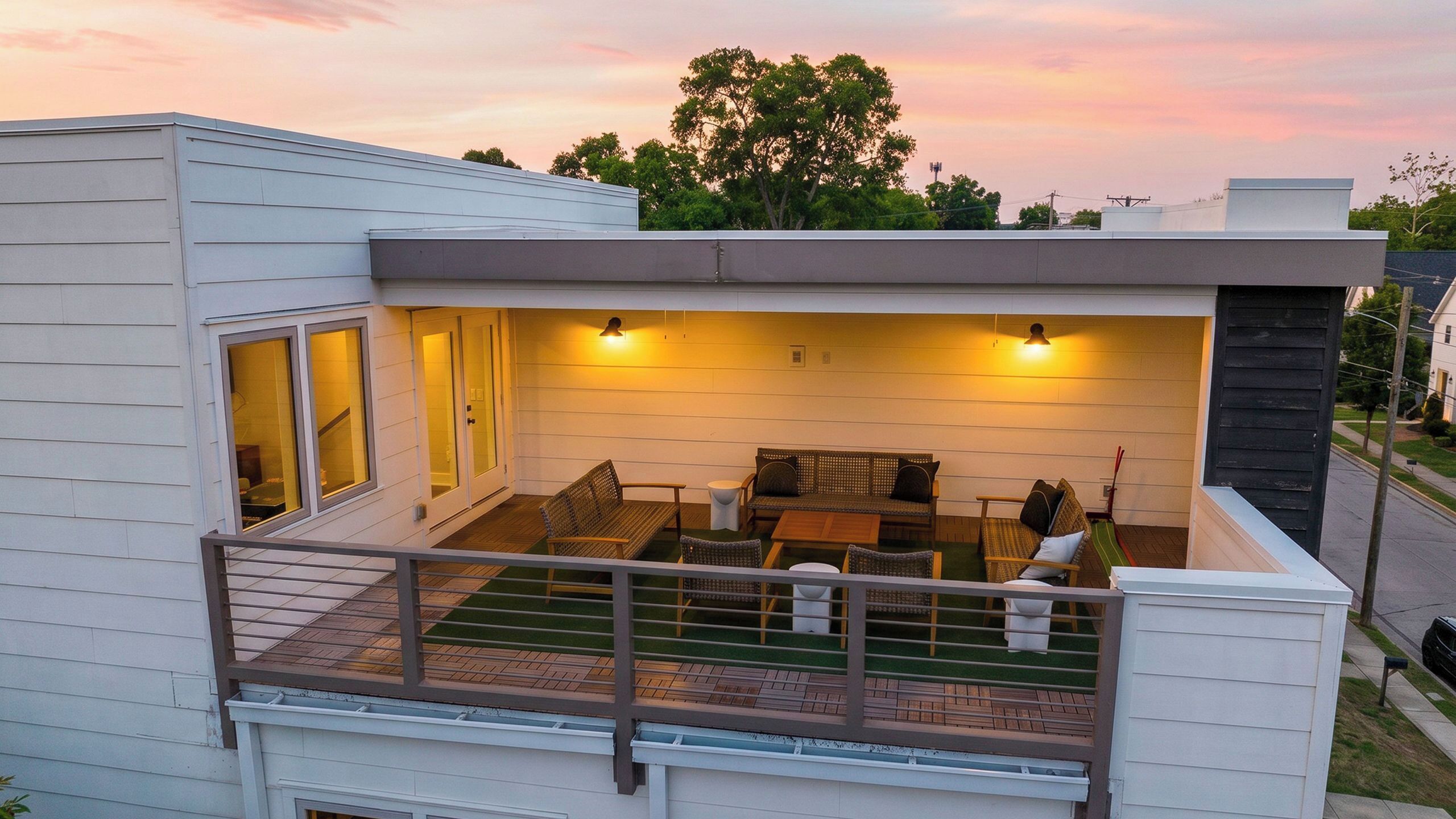 A modern house with a balcony, a patio with furniture, and a view of the sky.