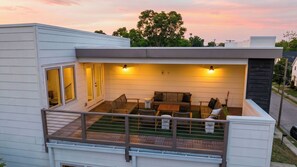 A modern house with a balcony, a patio with furniture, and a view of the sky. - The Mod Buchanan by Avantstay Hot Tub + Rooftop Putting Mat + Game Room (Nashville)