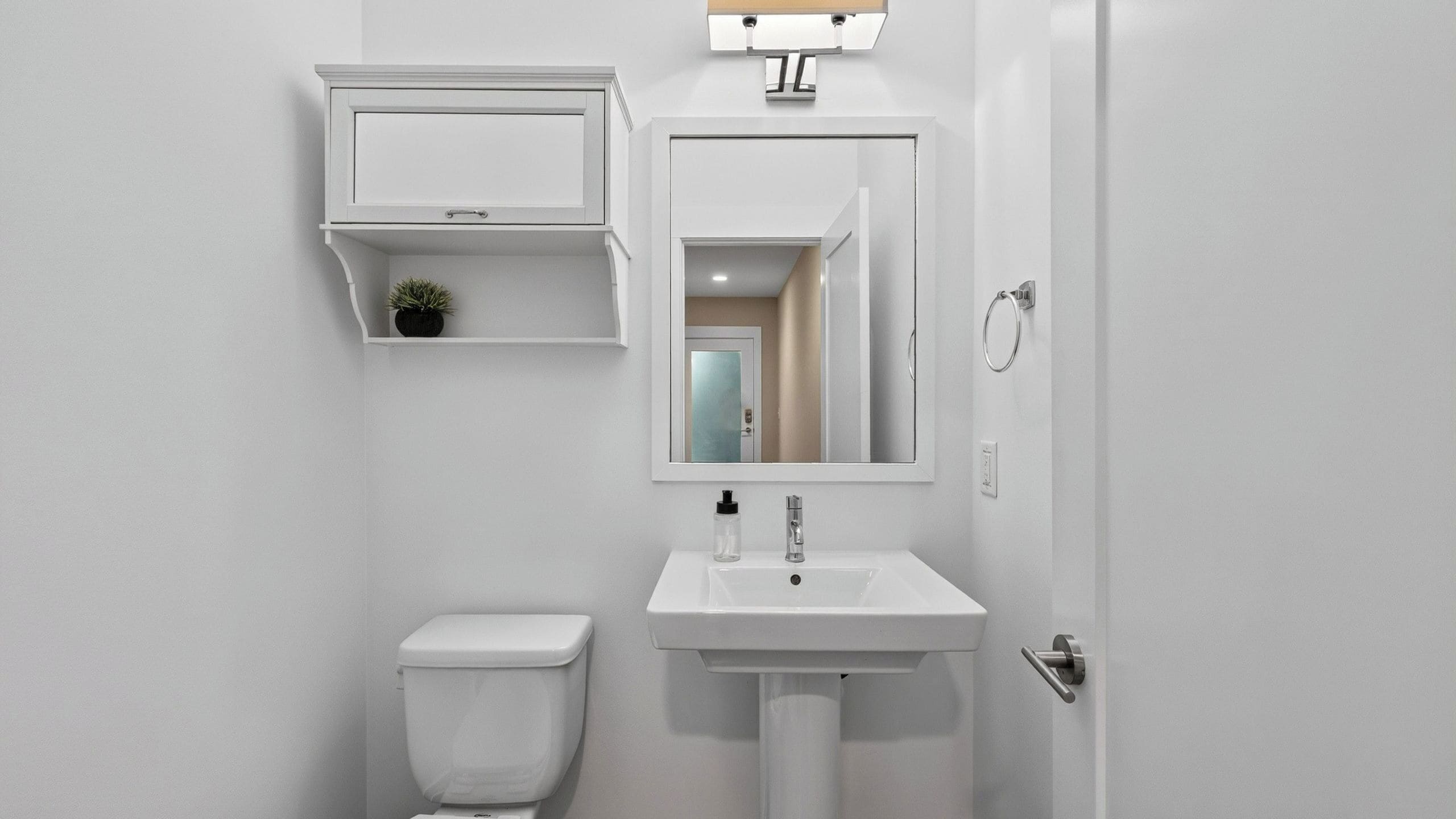 Ein Badezimmer mit Toilette, Waschbecken, Spiegel und Ablage über dem Waschbecken.