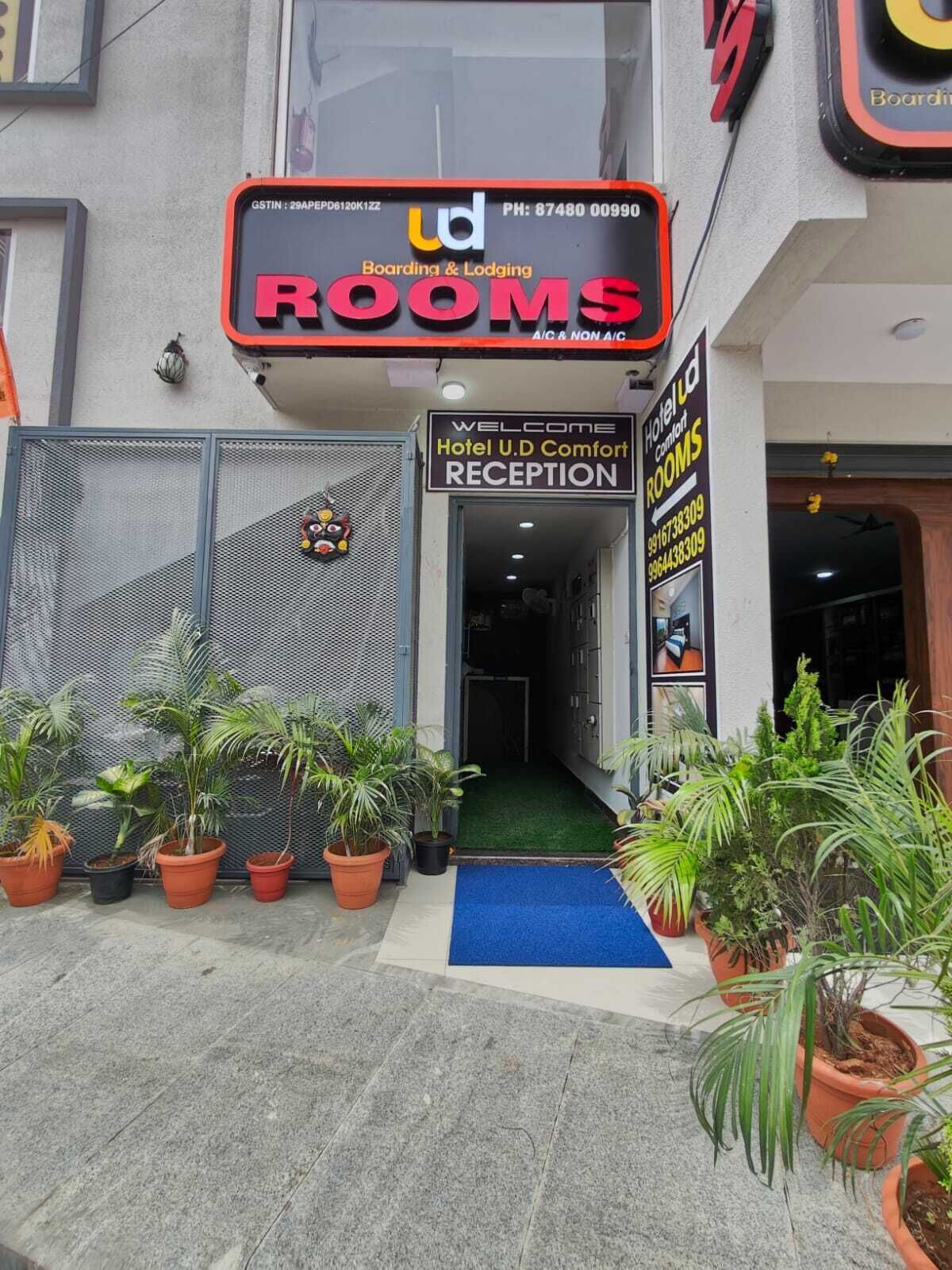 A hotel entrance with a sign for 'Hotel U.D Comfort Rooms' and a reception area.