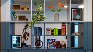 Una libreria con diversi oggetti, tra cui libri, una pianta e soprammobili.