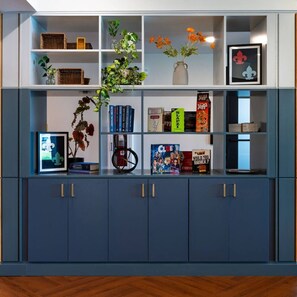 Een boekenplank met diverse objecten, waaronder boeken, een plant en decoratieve items.