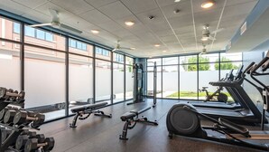 Una palestra con attrezzature da allenamento, ampie finestre e vista sull'esterno.
