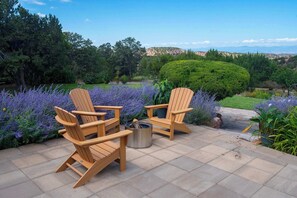 An outdoor patio with two Adirondack chairs and a metal fire pit. - Sunset Mountain Casita - 1 Bedroom (Santa Fe)