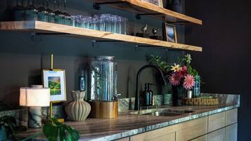 Eine Küche mit Holzböden, einer Spüle, einer Blumenvase und einer Lampe.