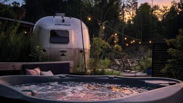 A hot tub with a view of a trailer labeled 'AIRSTREAM' in the background.