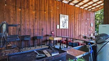 A rustic outdoor dining area with wooden walls, metal furniture, and a fire extinguisher.