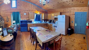 A log cabin with a dining area, kitchen, and a fireplace. - Log Cabin 2-bedroom lake view 20 minutes to Branson (Forsyth)