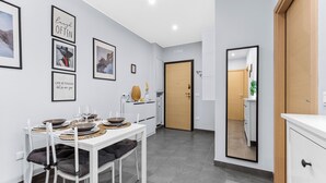 A modern kitchen with white cabinetry, a dining table set with plates and glasses, and framed motivational quotes on the wall. - Scarlatti31 - Beautiful apartment in the heart of Milan, Milan Central Station (Milano)