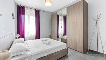 Una camera da letto moderna con un letto grande, un armadio e uno specchio.