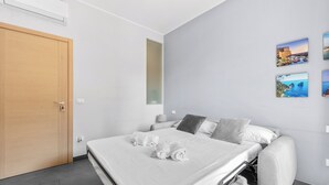 A modern hotel room with a bed, a wooden door, and a wall with three framed pictures. - Scarlatti31 - Beautiful apartment in the heart of Milan, Milan Central Station (Milano)