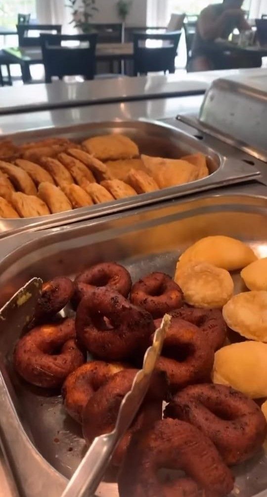 A buffet with various food items including donuts and pastries.