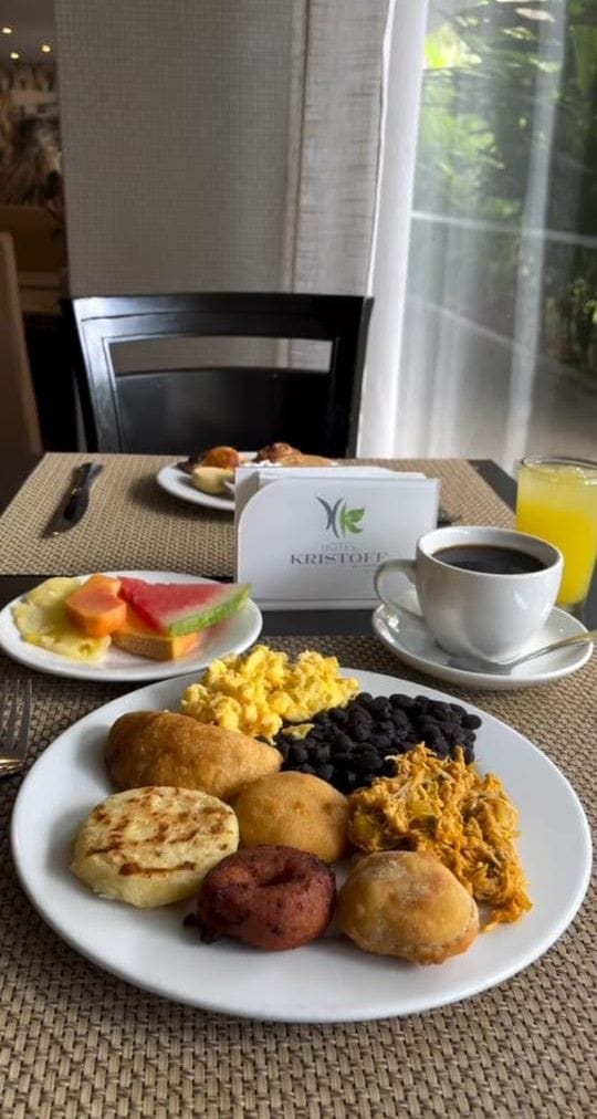 Una escena de desayuno con un plato de comida, una taza de café y un vaso de jugo.