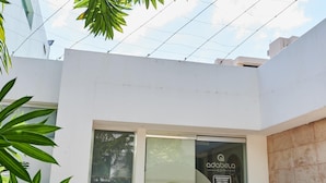 A modern building with a glass entrance, a spa sign, and outdoor seating. - Hotel Kristoff (Maracaibo)