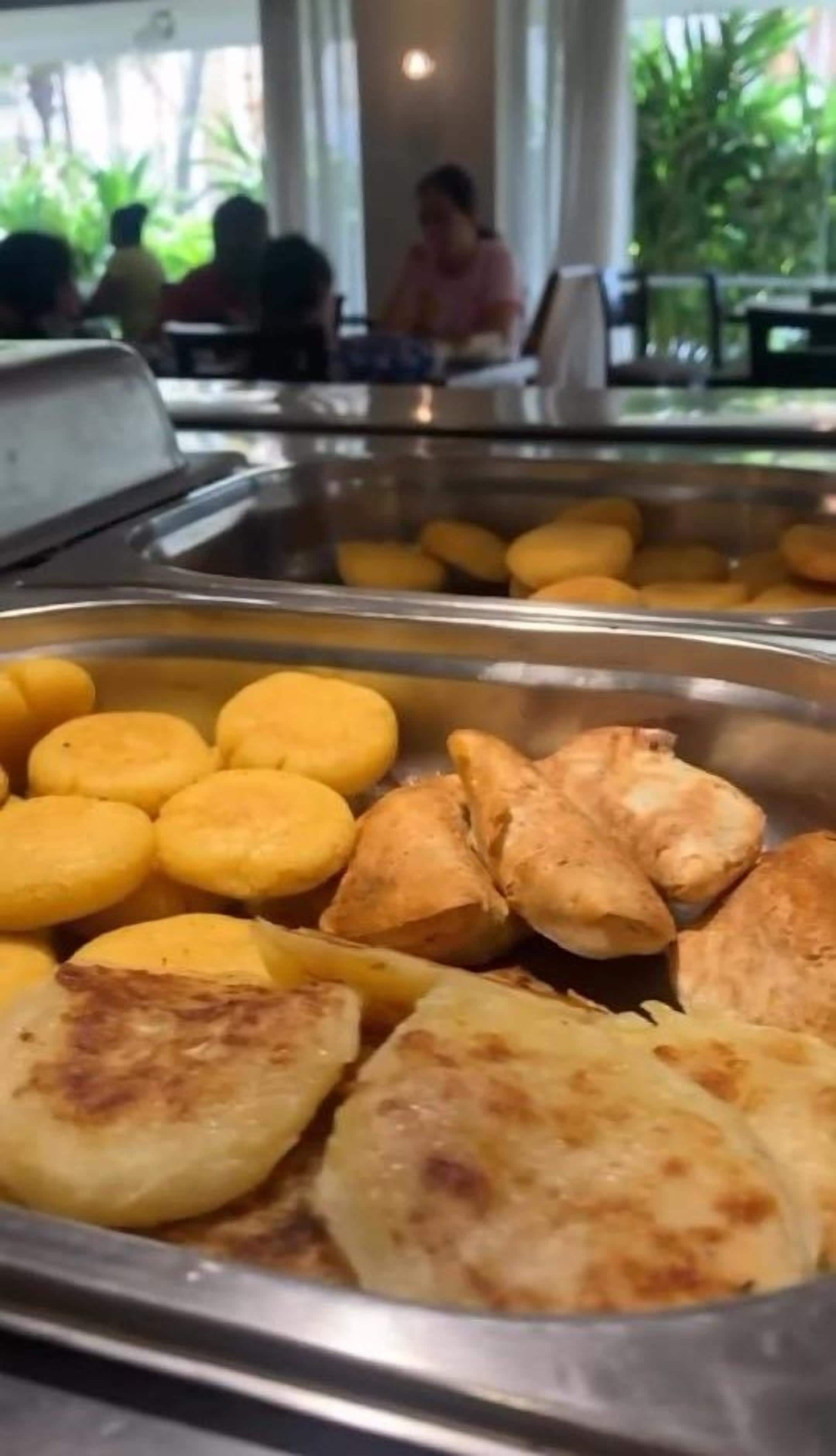 Un bufé con diversos alimentos, incluyendo pasteles dorados y elementos de color amarillo.