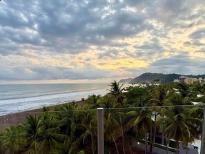 A beach view with palm trees and a cloudy sky. - Diamante 701n - Downtown Jaco Deluxe Penthouse (Jaco)