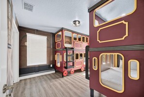 Ein Zimmer mit einem Etagenbett und einem Einzelbett, beide im klassischen Stil.
