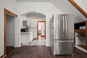A modern kitchen with white cabinetry, a stainless steel refrigerator, and a wooden ceiling. - Spacious 6-bedroom house in peaceful Fayetteville (Fayetteville)